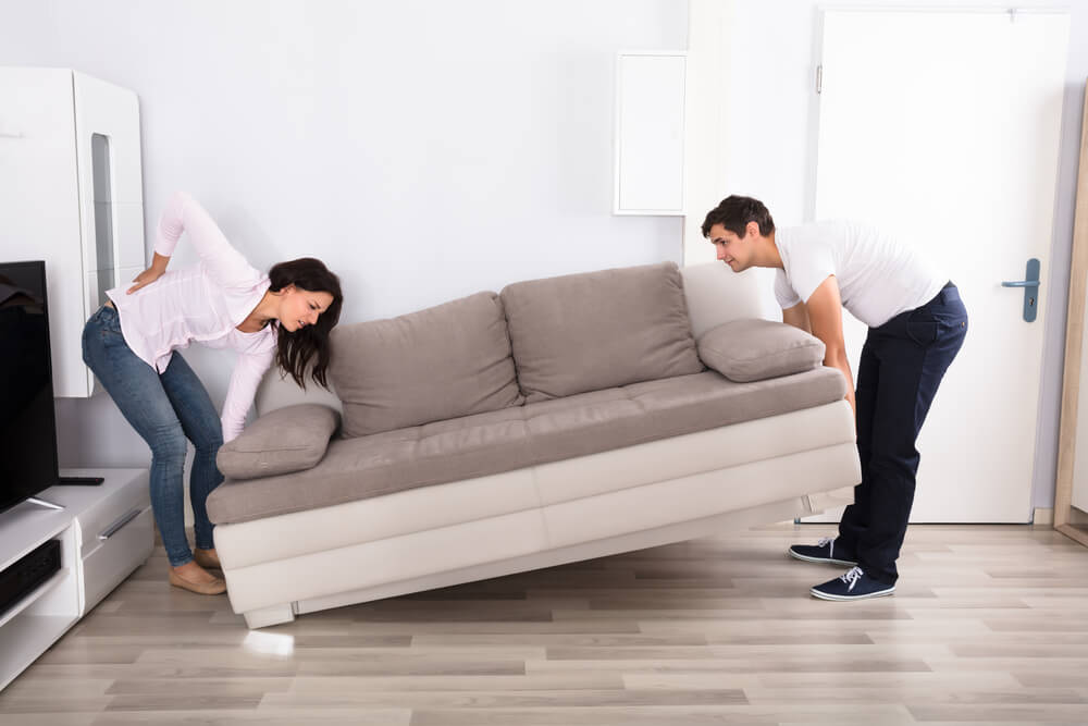 a couple is moving a sofa