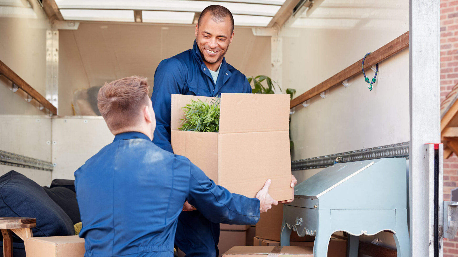 two movers on truck loading boxes