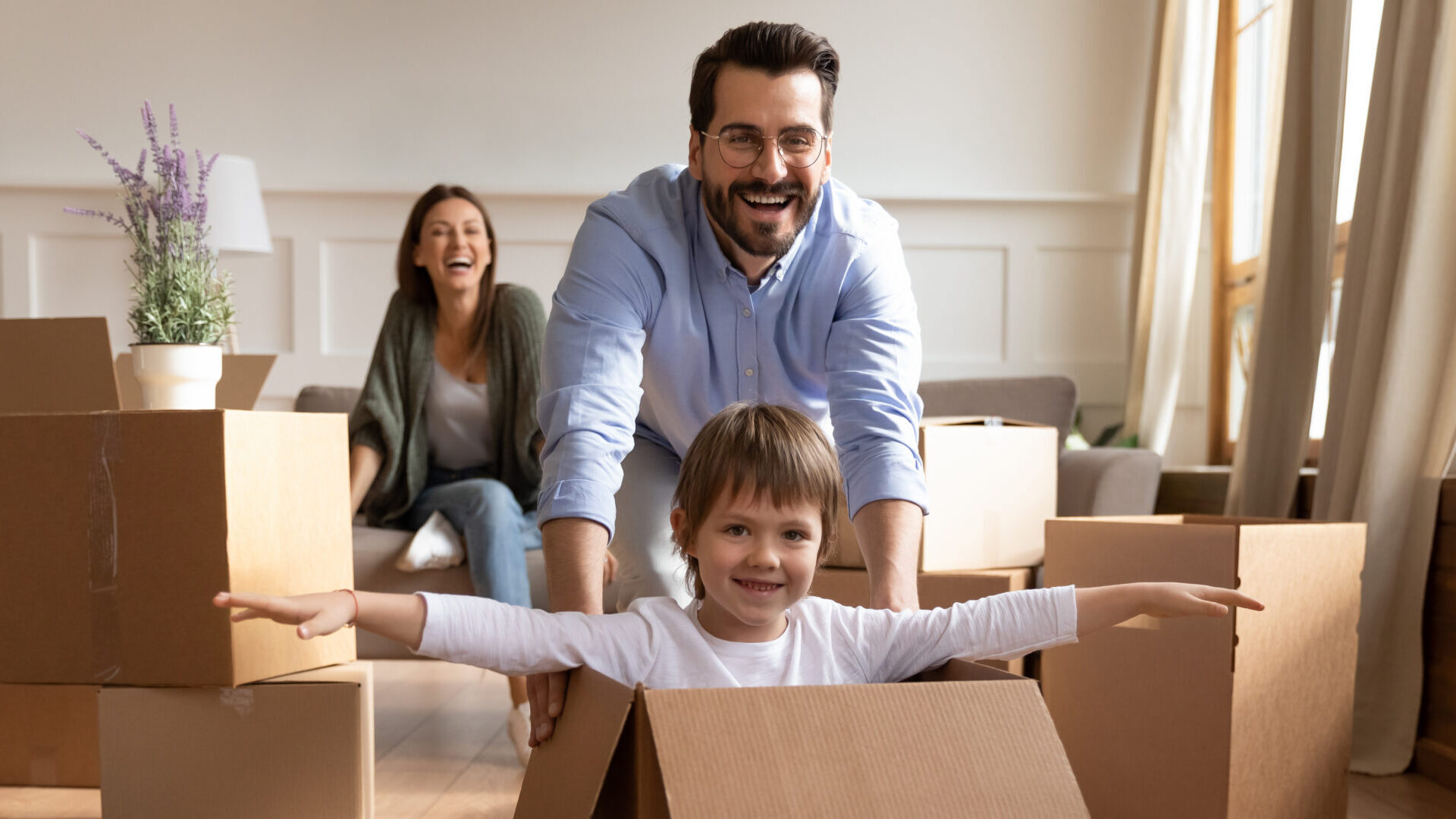 child in box being pushed by dad