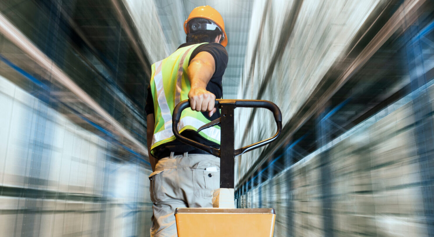 man in warehouse pulling boxes