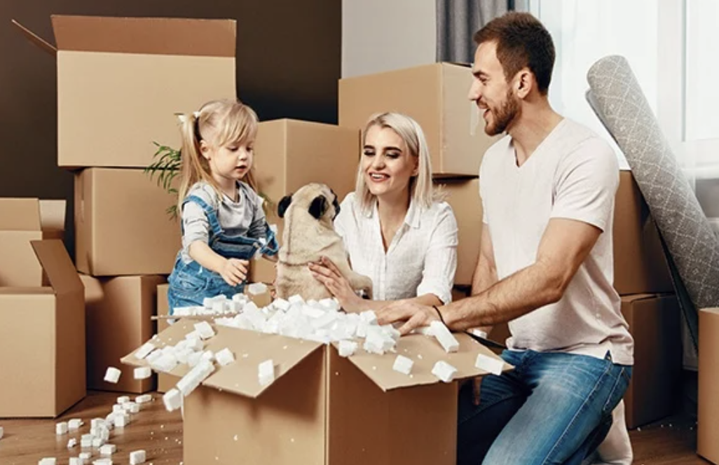 Parents, child and dog packing boxes